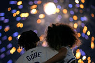Former Kansas City Royal Terrance Gore and his daughter watch fireworks after a baseball game between the Royals and the Oakland Athletics Friday, May 17, 2024, in Kansas City, Mo. The Royals won 6-2. (AP Photo/Charlie Riedel)