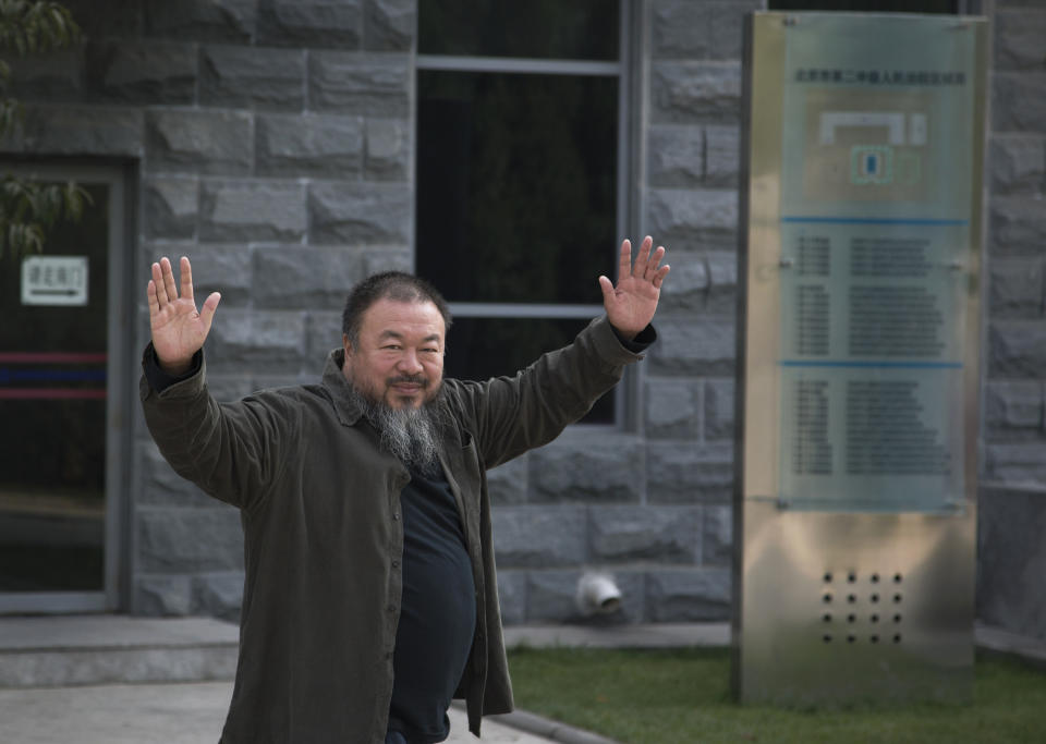 Chinese Activist artist Ai Weiwei waves to the journalists as he arrives to the Beijing No. 2 People's Intermediate Court in Beijing Thursday, Sept. 27, 2012. Chinese authorities on Thursday rejected Ai’s second appeal of a $2.4 million tax fine, meaning his design company will have to pay the penalty. (AP Photo/Andy Wong)