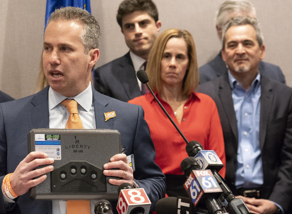 Michael Song, at right, and his wife, Kristen, center, along with legislators and gun-safety advocates, pushed for Connecticut to create requirements for safe gun storage. The bill was named "Ethan's Law" in memory of the son the Songs lost in a firearm accident at a friend's home. (Photo: Patrick Raycraft/Hartford Courant via Getty Images)