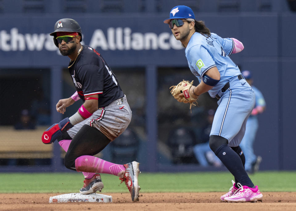 Toronto Blue Jays' Bo Bichette, right, looks to throw to first base as Minnesota Twins' Willi Castro, left, is forced out at second base during seventh-inning baseball game action in Toronto, Sunday, May 12, 2024. (Frank Gunn/The Canadian Press via AP)