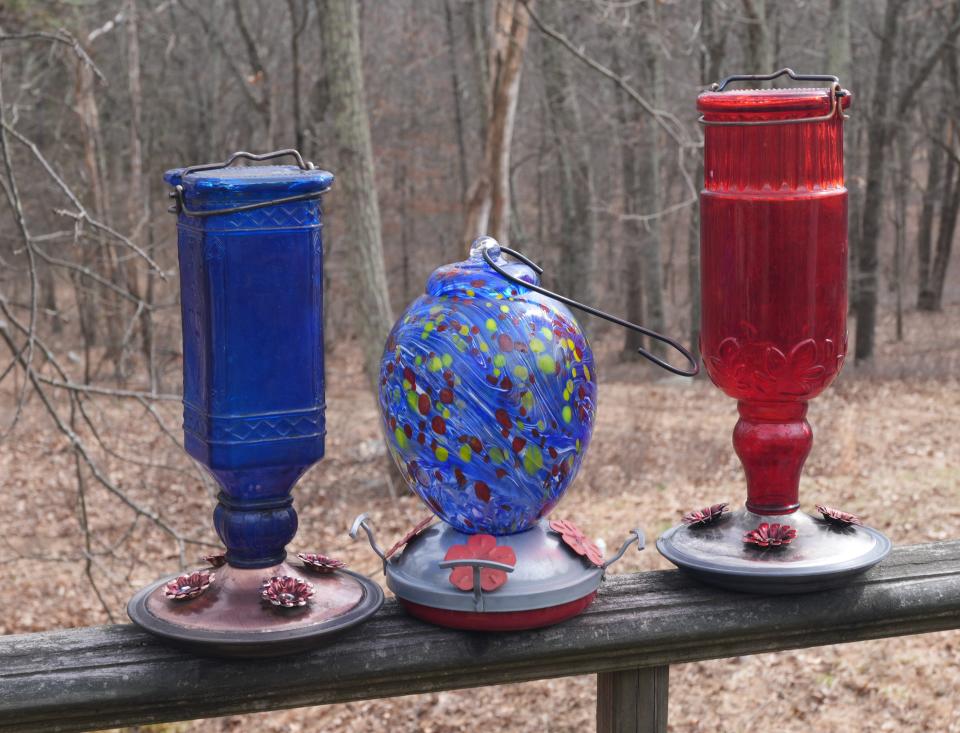 A collection of hummingbird feeders sits on a deck railing awaiting a cleaning and filling with nectar, The first hummingbirds usually appear in northern New Jersey by mid-April either as migrants heading further north or to find a mate in this area.