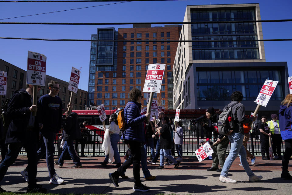Strikers march in front of Rutgers' buildings in New Brunswick, N.J., Monday, April 10, 2023. Thousands of professors, part-time lecturers and graduate student workers at New Jersey's flagship university have gone on strike — the first such job action in the school's 257-year history. (AP Photo/Seth Wenig)