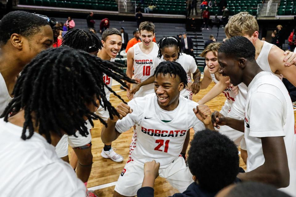 Grand Blanc players celebrate their 61-40 win over Belleville in the MHSAA Division 1 boys basketball state semfinals at Breslin Center in East Lansing on Friday, March 25, 2022.