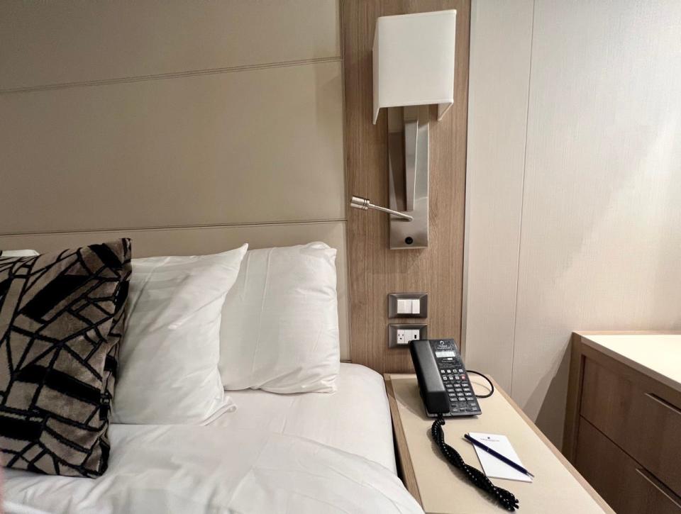 Lamp and outlets next to bed in cruise ship room on Holland America Line Rotterdam