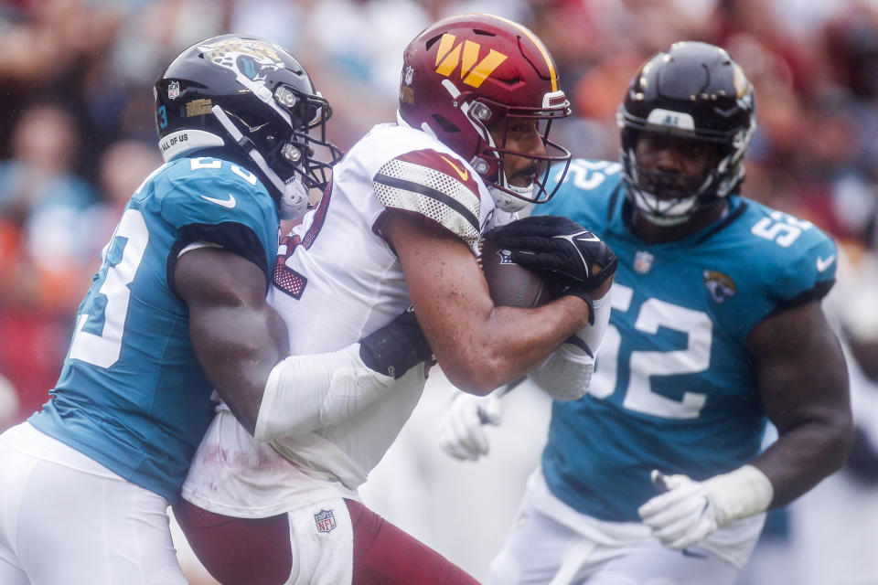 Washington Commanders tight end Logan Thomas (82) carries the ball as Jacksonville Jaguars cornerback Josh Thompson (23) and defensive tackle DaVon Hamilton (52) defend during the first half of a NFL football game between the Washington Commanders and the Jacksonville Jaguars on Sunday, Sept. 11, 2022 at FedExField in Landover, Md. (Shaban Athuman/Richmond Times-Dispatch via AP)