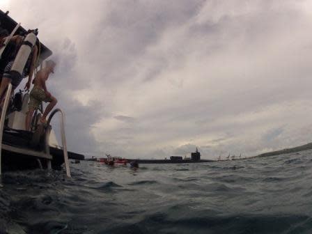 USC students complete a dive in May 2012 on Western Shoals reef as the nuclear submarine USS Michigan transits by the adjacent reef that would be dredged to accommodate an aircraft carrier. Photo by Kaitlin Mogentale