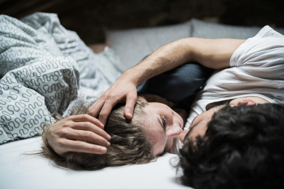 Two people affectionately resting together, one's hand on the other's head