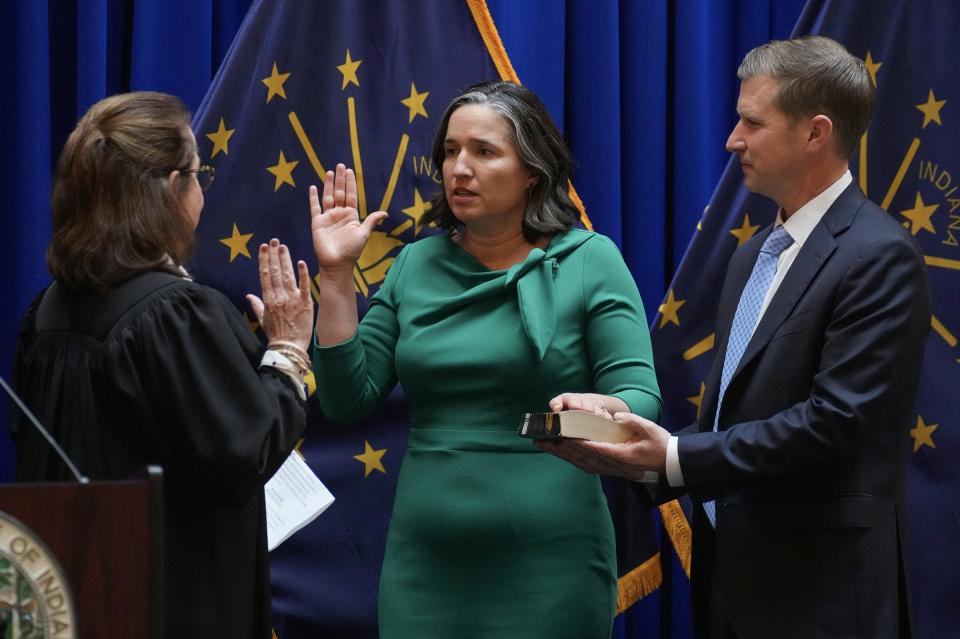 Indiana State Auditor Tera Klutz is sworn into office by the Hon. Loretta Rush, joined by Klutz's husband, Zach (right), on Monday, Jan. 9, 2023, at the Indiana Statehouse in Indianapolis.