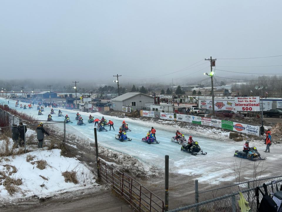 Drivers attempt to overtake each other after a break in the action during the 55th running of the annual I-500 snowmobile race on Feb. 3, 2024.