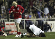 FILE - British MP and player for England, Boris Johnson, left, looks at Germany's player Maurizio Gaudino after tackling him during a charity match at the Madjeski stadium in Reading, England, Wednesday May 3, 2006. (AP Photo/Tom Hevezi, File)