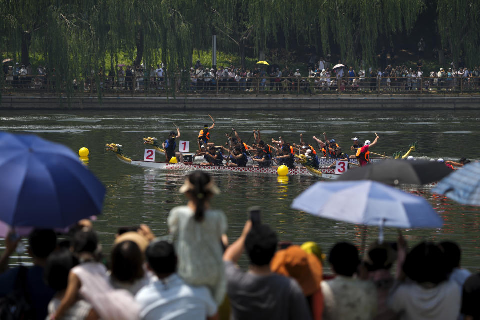 People watch the dragon boat races during the Dragon Boat Festival at a canal in Tongzhou, outskirts of Beijing, Monday, June 10, 2024. The Duanwu Festival, also known as the Dragon Boat Festival, falls on the fifth day of the fifth month of the Chinese lunar calendar and is marked by eating rice dumplings and racing dragon boats. (AP Photo/Andy Wong)