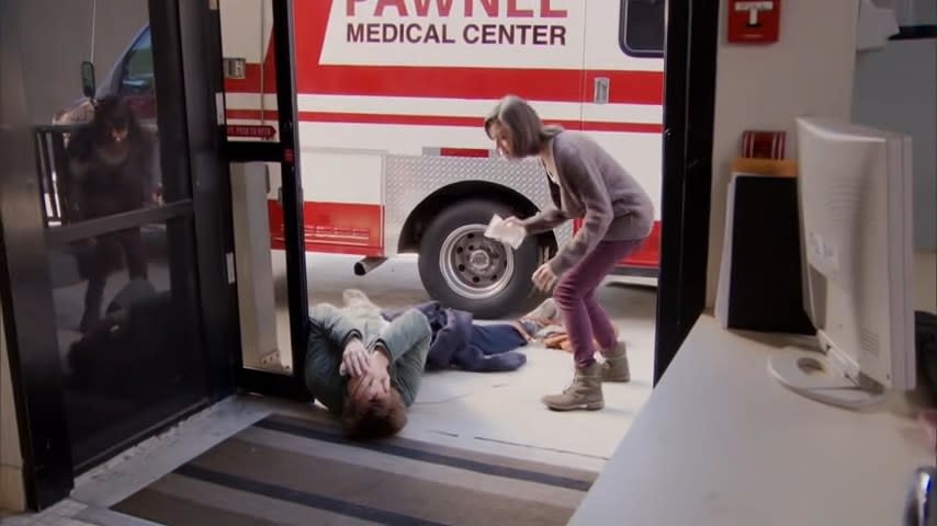 Andy lying hurt in front of an ambulance with April in "Parks and Recreation"