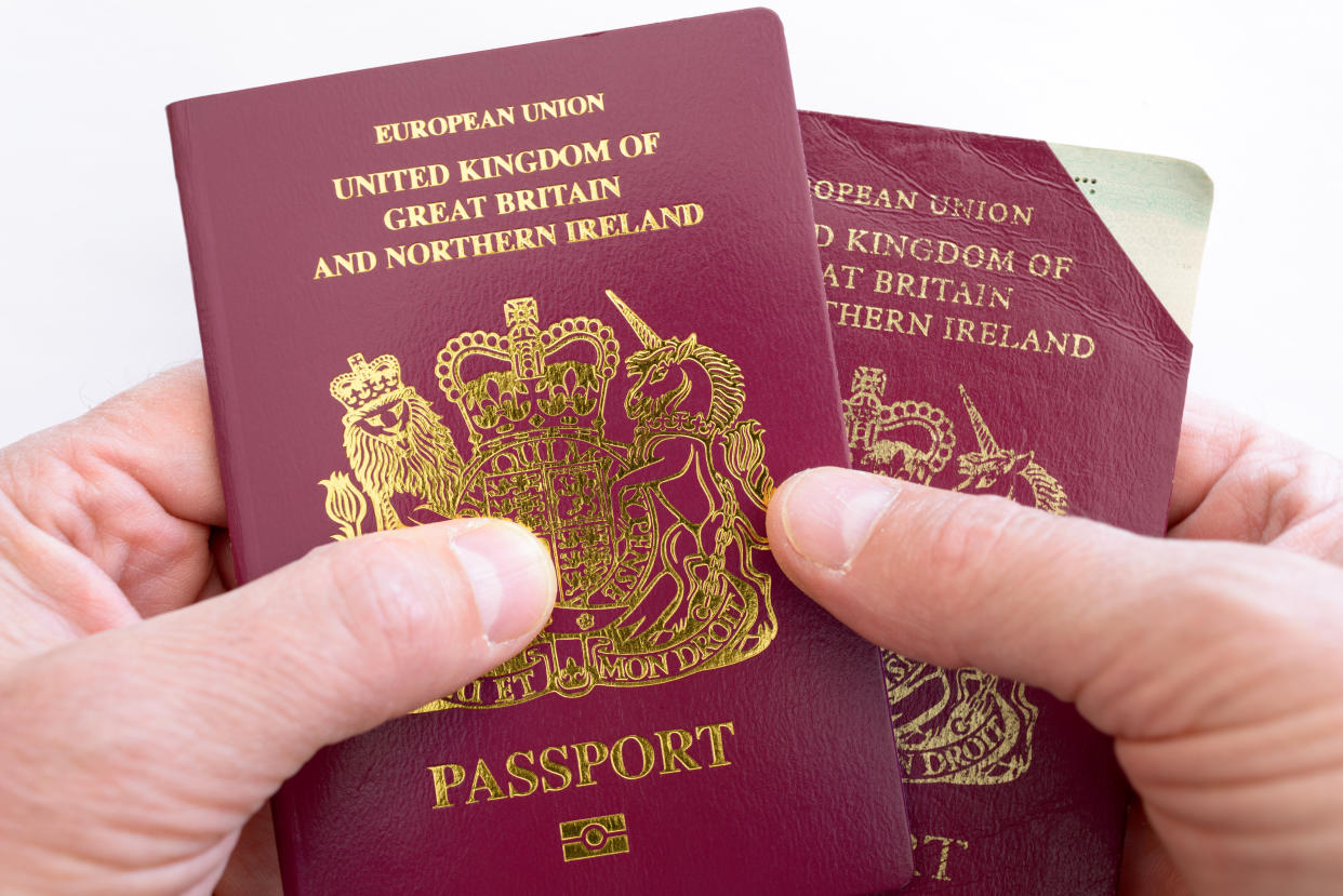 Antibes, France - September 29, 2018: Man holds new maroon UK passport, and invalidated UK passport with cut off top right corner.