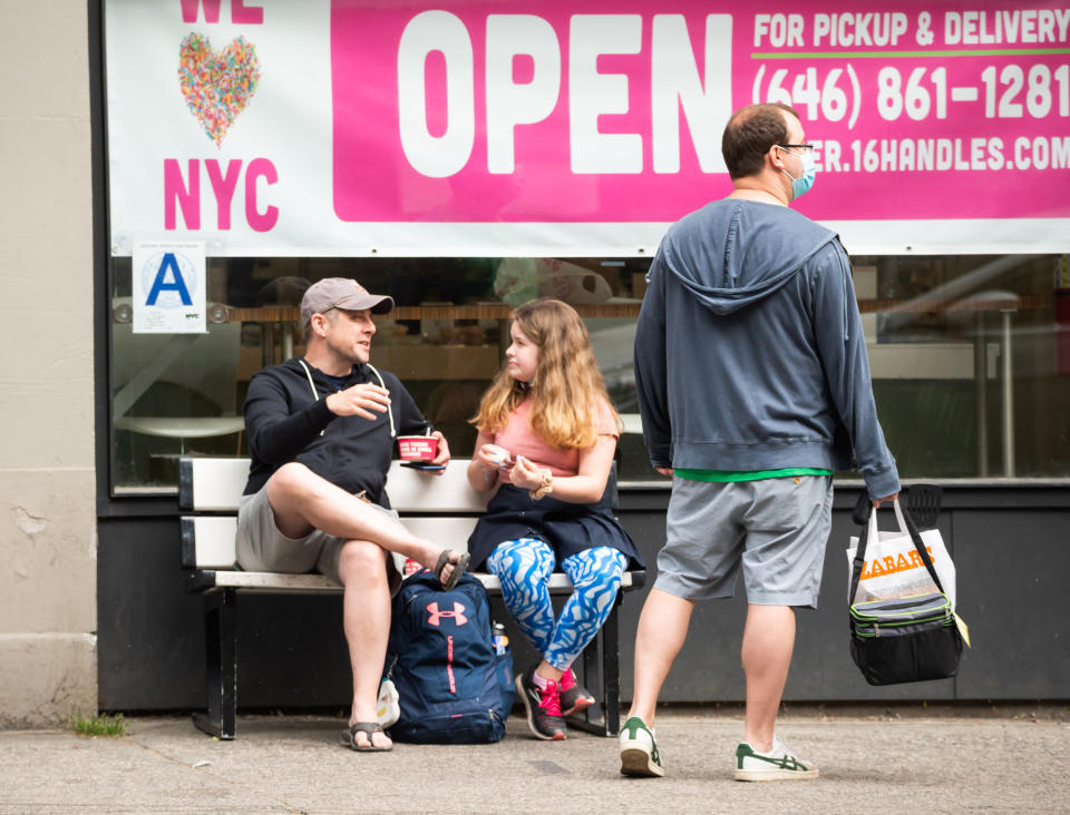 NEW YORK, NEW YORK - MAY 24: People eat frozen yogurt outside 16 Handles on the Upper West Side on May 24, 2021 in New York City. On May 19, all pandemic restrictions, including mask mandates, social distancing guidelines, venue capacities and restaurant curfews were lifted by New York Governor Andrew Cuomo. (Photo by Noam Galai/Getty Images)