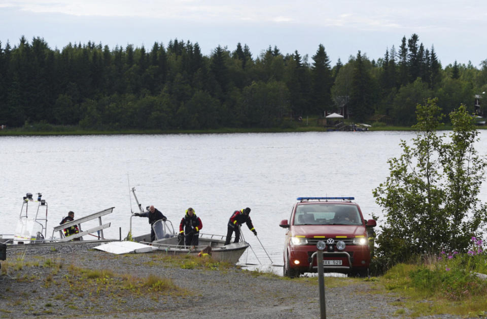 Emergency services attend the accident site at a small harbor at Ume river, outside Umea, Sweden, Sunday July 14, 2019. Swedish officials say a small plane carrying parachutists crashed in northern Sweden and all nine of the people on board were killed. (Samuel Pettersson/TT via AP)