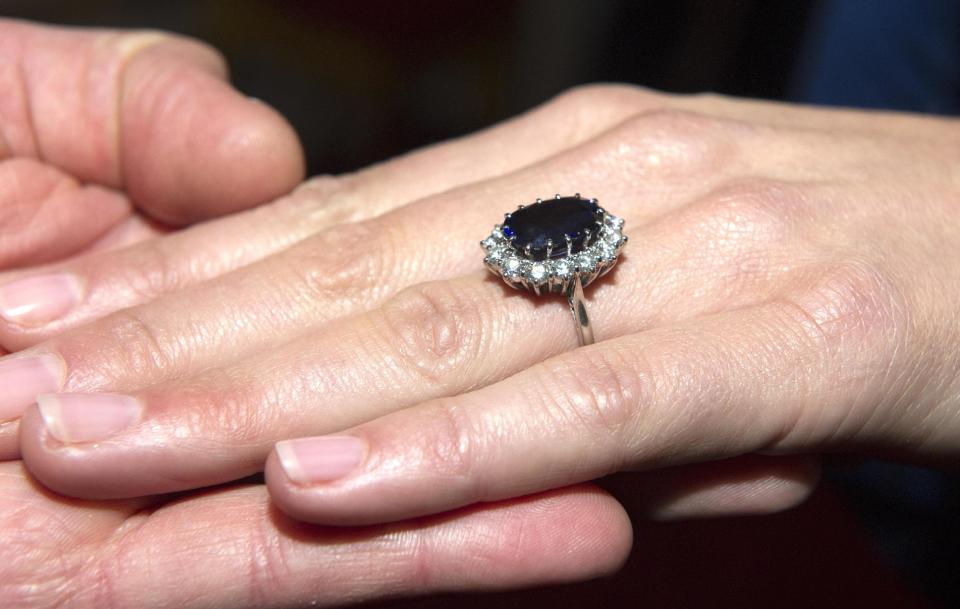 FILE - In this May 16, 2010 file photo, Prince William holds Kate Middleton's hand with her engagement ring which once belonged to Diana, Princess of Wales, on the day their engagement was announced in London. Prince William revealed that he proposed using the engagement ring of his mother, Diana, Princess of Wales, to make sure Diana "didn't miss out on the excitement." Publicity surrounding the royal engagement ring sparked an interest among average consumers in adding gemstones like sapphires and rubies to their diamond engagement rings, according to Melissa Colgan, senior style editor of Martha Stewart Weddings. (AP Photo/Arthur Edwards, pool, File)