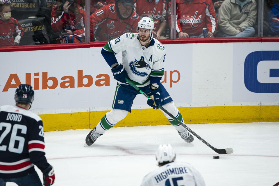 Vancouver Canucks defenseman Oliver Ekman-Larsson (23) looks for an open teammate during the third period of an NHL hockey game against the Washington Capitals, Sunday, Jan. 16, 2022, in Washington. (AP Photo/Al Drago)