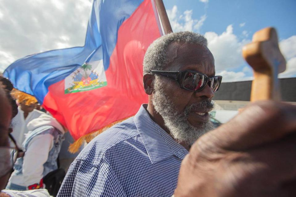 David Degalait hols a cross and a Haitian flag during procession when Archbishop Wenski celebrates the Liturgy of the Lord’s Passion, the Veneration of the Cross procession at The Cathedral of St. Mary, in Miami on Friday March 29th., 2024.