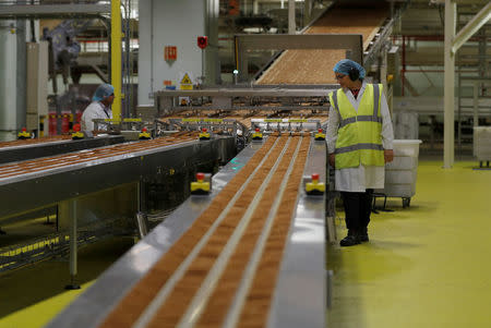 A worker inspects biscuits on the production line of Pladis' McVities factory in London Britain, September 19, 2017. Picture taken September 19, 2017. REUTERS/Peter Nicholls.