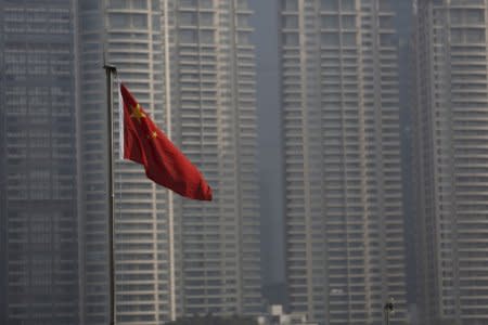 FILE PHOTO: A Chinese flag is seen in front of the financial district of Pudong in Shanghai, China, January 19, 2016. REUTERS/Aly Song/File Photo