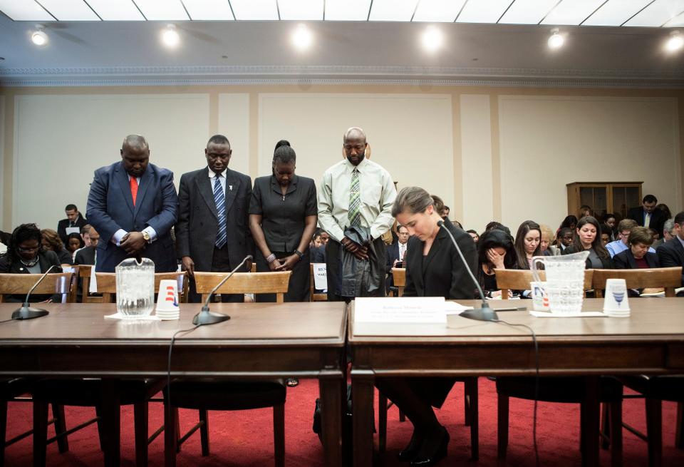 Lawyer Benjamin Crump stands with Sybrina Fulton and Tracy Martin, parents of Trayvon Martin, as they bow their heads for a moment of silence with Rebecca Monroe, right, then acting director of the Community Relations Service at the Justice Department, during a forum of Democratic members of the House Judiciary Committee, March 27, 2012.