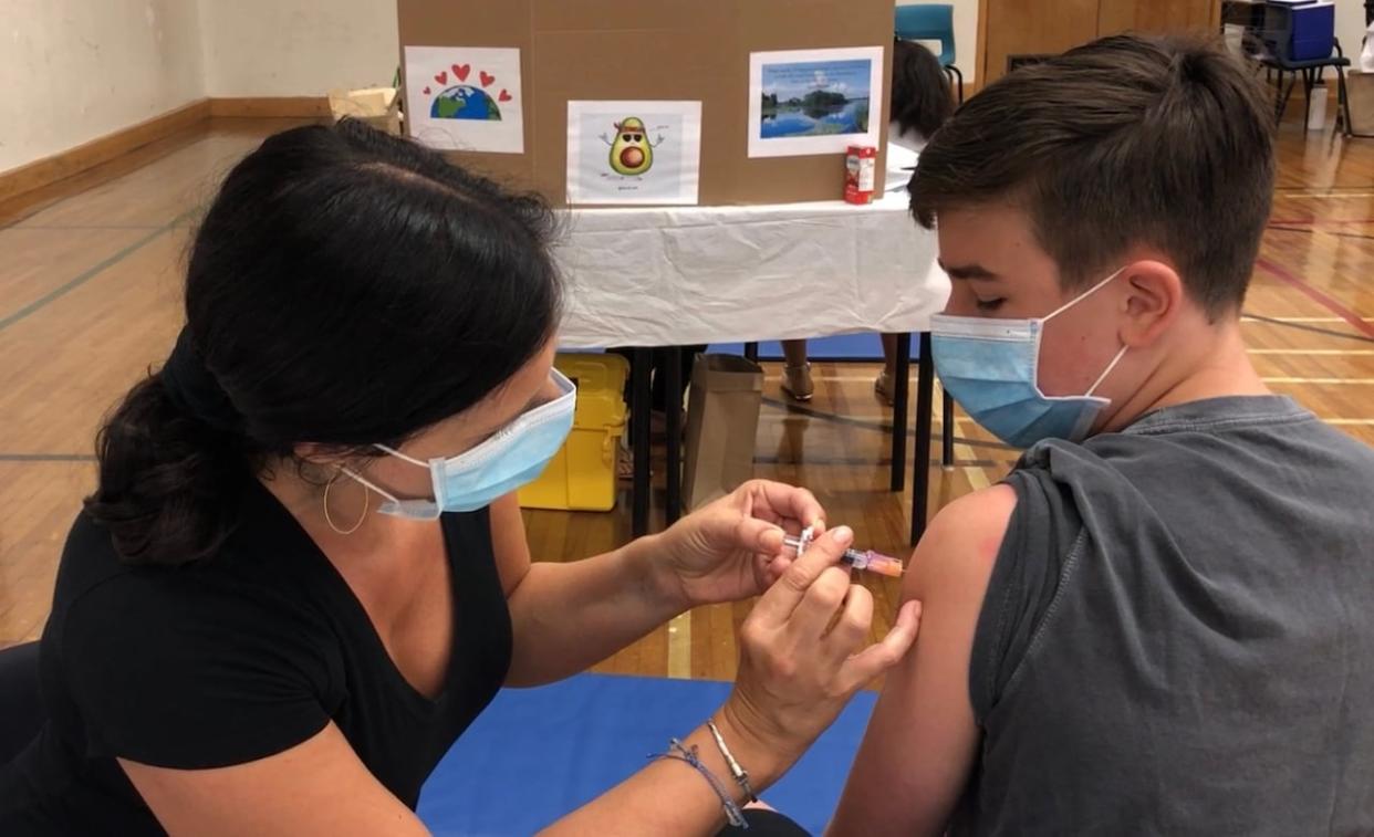 A Grade 7 student receives a routine vaccine that covers human papillomavirus, hepatitis B, meningococcal disease and tetanus, diphtheria and acellular pertussis at a Canadian vaccination clinic. (Craig Paisley/CBC - image credit)