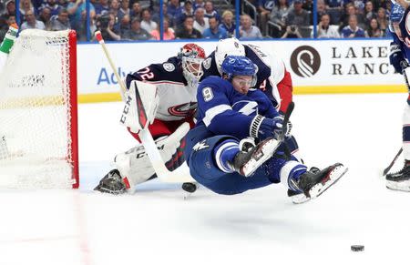 Apr 10, 2019; Tampa, FL, USA; Columbus Blue Jackets defenseman Scott Harrington (4) defends Tampa Bay Lightning center Tyler Johnson (9) during the first period of game one of the first round of the 2019 Stanley Cup Playoffs at Amalie Arena. Mandatory Credit: Kim Klement-USA TODAY Sports