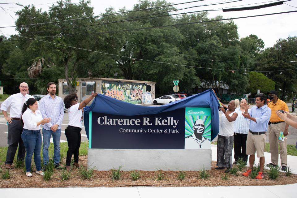 Gainesville city commissioners, including District 1 Gainesville City Commissioner Desmon Duncan-Walker, left side of unveiling of the signage, and neighborhood representatives unveil the sign during the official grand opening ceremony of the newly rebuilt Clarence R. Kelly Community Center and Park on Northeast Eighth Avenue in Gainesville on June 19. (Lawren Simmons/Special to The Guardian)