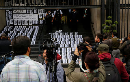 A photographer takes pictures of images of reporter Candido Rios, who was killed in Veracruz, during a demonstration against his killing, at the Interior Ministry building in Mexico City, Mexico August 24, 2017. REUTERS/Henry Romero