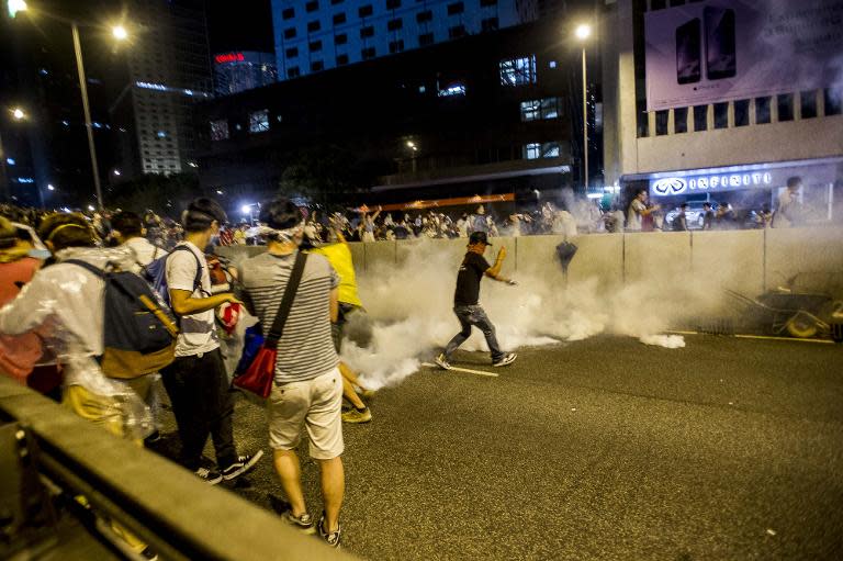 Protesters take cover as police fire tear gas at a pro-democracy protest in Hong Kong