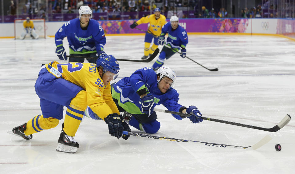 Sweden forward Gabriel Landeskog, left, and Slovenia forward Jan Urbas vie for the puck in the second period of a men's quarterfinal ice hockey game at the 2014 Winter Olympics, Wednesday, Feb. 19, 2014, in Sochi, Russia. (AP Photo/Julio Cortez)