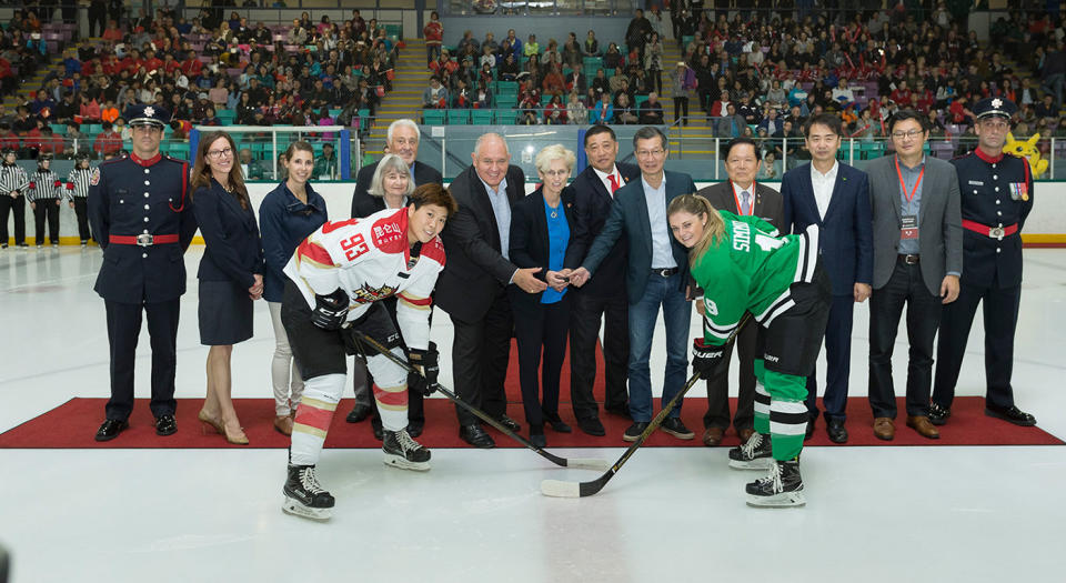 Players and management pose during the ceremonial puck drop before Kunlun’s inaugural game in Markham, Ont. (Chris Tanouye/CWHL)