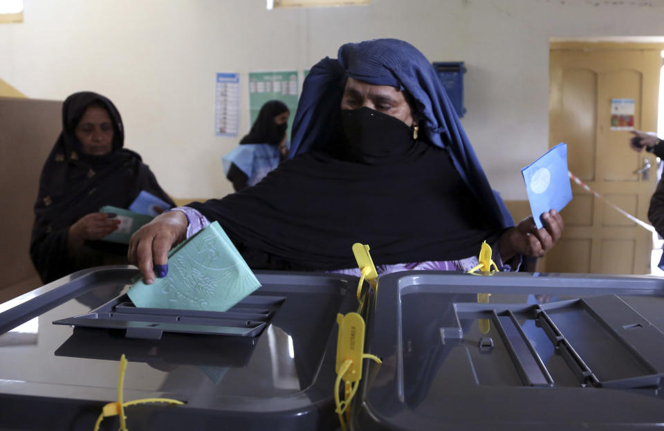 An Afghan woman casts her vote at a polling station in Jalalabad east of Kabul, Afghanistan, Saturday, April 5, 2014. Afghan voters lined up for blocks at polling stations nationwide on Saturday, defying a threat of violence by the Taliban to cast ballots in what promises to be the nation's first democratic transfer of power. (AP Photo/Rahmat Gul)