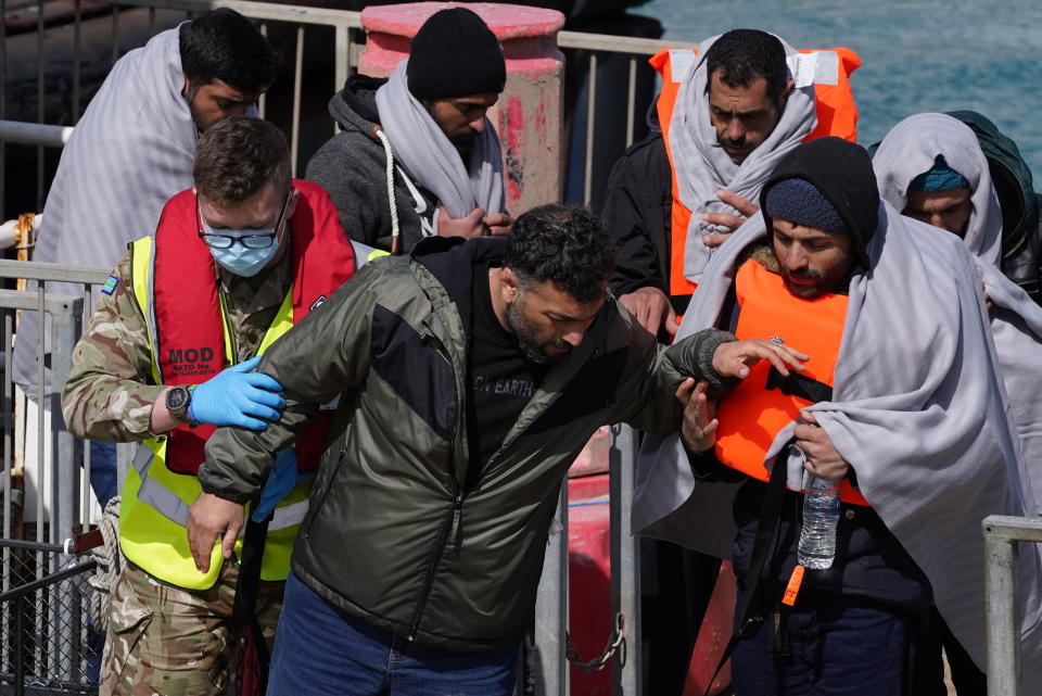 A group of people thought to be migrants are brought in to Dover, Kent, by the RNLI, following a small boat incident in the Channel, Thursday April 14, 2022. Britain's Conservative government has struck a deal with Rwanda to send some asylum-seekers thousands of miles away to the East African country, a move that opposition politicians and refugee groups condemned as inhumane, unworkable and a waste of public money. (Gareth Fuller/PA via AP)