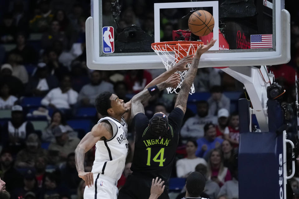 New Orleans Pelicans forward Brandon Ingram (14) goes to the basket against Brooklyn Nets center Nic Claxton in the first half of an NBA basketball game in New Orleans, Tuesday, Jan. 2, 2024. (AP Photo/Gerald Herbert)