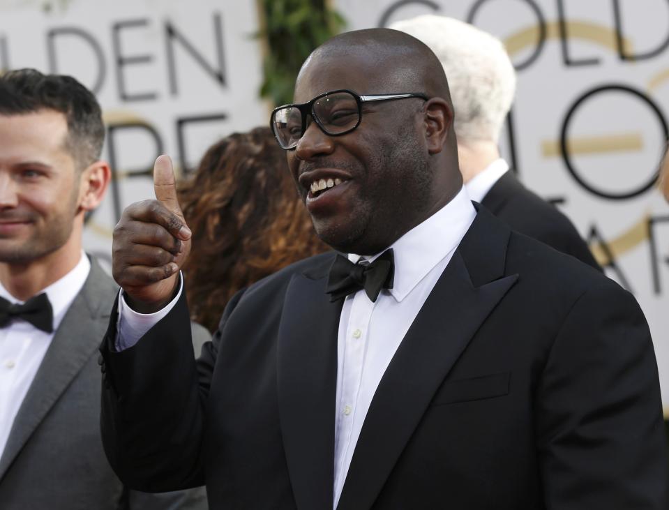 Director Steve McQueen gives a thumbs up as he arrives at the 71st annual Golden Globe Awards in Beverly Hills