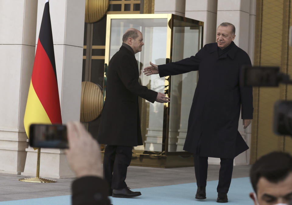 Turkish President Recep Tayyip Erdogan, shows the way to Germany's Chancellor Olaf Scholz during a ceremony in Ankara, Turkey, Monday, March 14, 2022. Scholz is visiting Turkey Monday in his first official trip to the country since he took office in December. He will hold talks with Turkish President Recep Tayyip Erdogan in Ankara.(AP Photo/Burhan Ozbilici)