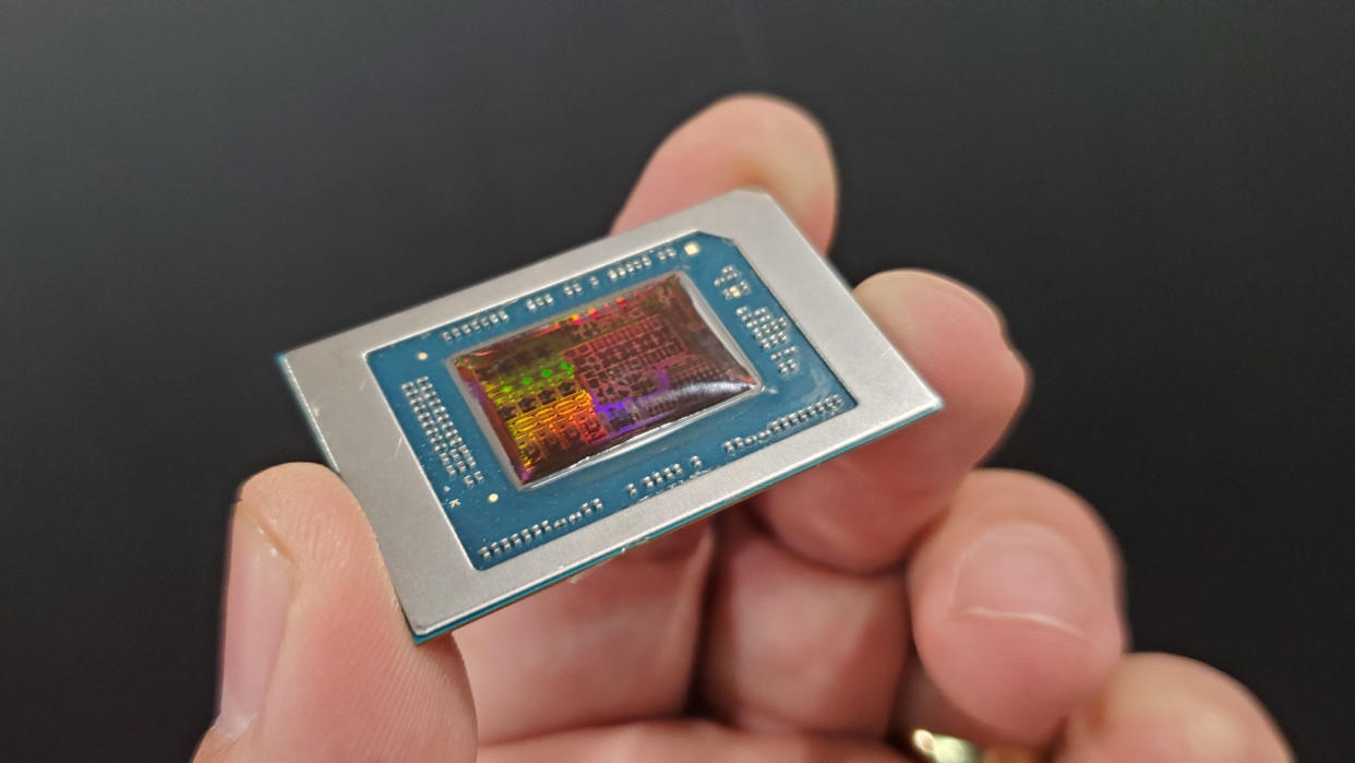  AMD Strix Point APU chip, held in a hand, with the reflected light showing the various processing blocks in the chip die. 