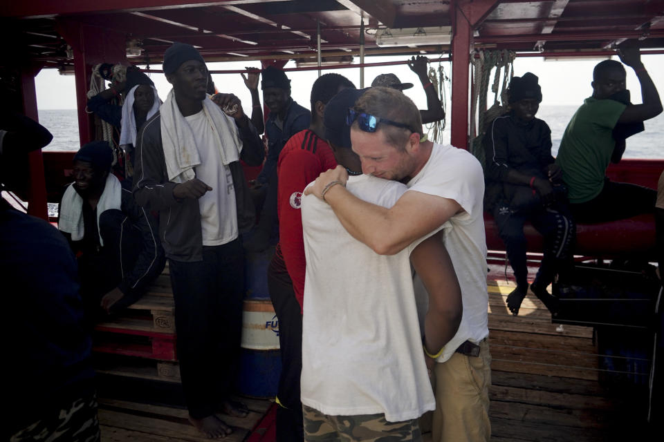 Basile Fischer, SOS Mediterranee's deputy search and rescue coordinator, right, hugs one of the rescued men aboard the Ocean Viking in the Mediterranean Sea, Monday, Sept. 23, 2019. Italy has granted the ship permission to sail to the port of Messina in Italy to disembark 182 migrants rescued north of Libya. (AP Photo/Renata Brito)