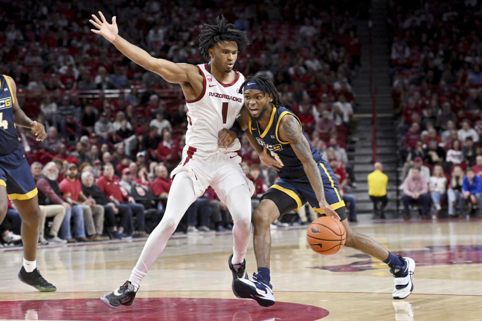 UNC Greensboro guard Kobe Langley (3) drives against Arkansas guard Ricky Council IV (1) during the first half of an NCAA college basketball game Tuesday, Dec. 6, 2022, in Fayetteville, Ark. (AP Photo/Michael Woods)