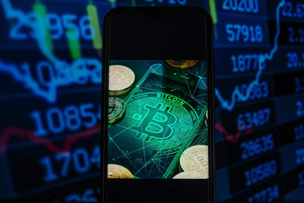 POLAND - 2021/05/18: In this photo illustration a Bitcoin logo seen displayed on a smartphone with stock market percentages in the background. (Photo Illustration by Omar Marques/SOPA Images/LightRocket via Getty Images)