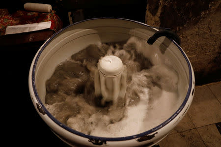 A washing machine is filled with reused water in an apartment block in downtown in Caracas, Venezuela, March 19, 2019. REUTERS/Carlos Jasso