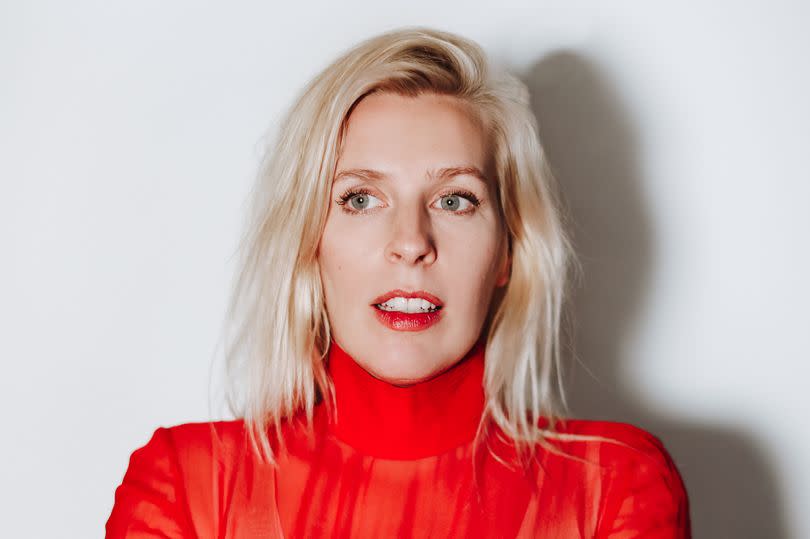 Sara Pascoe in a red top folding her arms