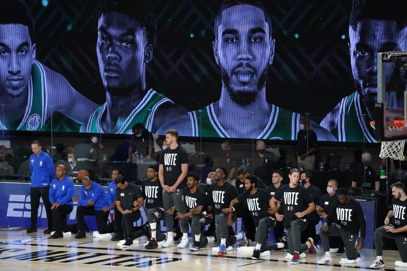 Members of the Miami Heat wear shirts that read "Vote," during the national anthem before Game 1 of the NBA basketball Eastern Conference final against the Boston Celtics on Tuesday, Sept. 15, 2020, in Lake Buena Vista, Fla. (AP Photo/Mark J. Terrill)