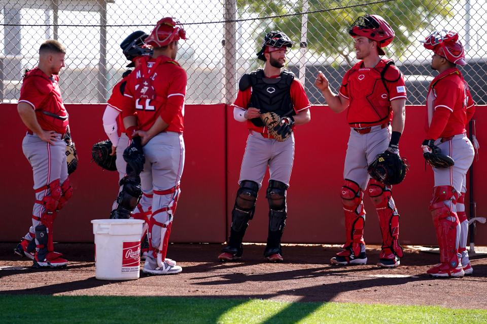 Cincinnati Reds catcher Tyler Stephenson (37), second from right, talks with other catchers during spring training workouts, Thursday, Feb. 15, 2024, at the team’s spring training facility in Goodyear, Ariz.