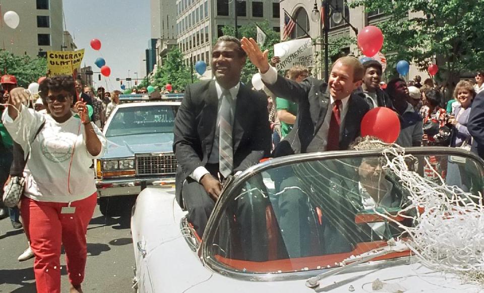 Charlotte Mayor Harvey Gantt, left, and Hornets principal owner George Shinn wave to the crowd during a parade in uptown Charlotte celebrating the new NBA team on April 24, 1987. The Hornets began NBA play in 1988.