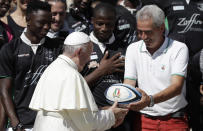 Pope Francis is presented with an oval, as he meets members of a rugby team formed by refugees at the end of his general audience in St. Peter's Square at the Vatican Wednesday, Sept. 12, 2018. (AP Photo/Alessandra Tarantino)