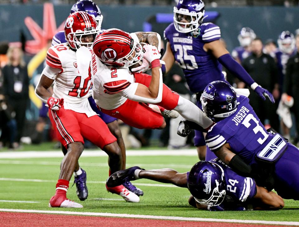 Utah Utes running back Micah Bernard (2) scores a touchdown with Northwestern Wildcats defensive back Jaheem Joseph (3) hanging onto his foot as Utah and Northwestern play in the SRS Distribution Las Vegas Bowl at Allegiant Stadium on Saturday, Dec. 23, 2023. Northwestern won 14-7. | Scott G Winterton, Deseret News