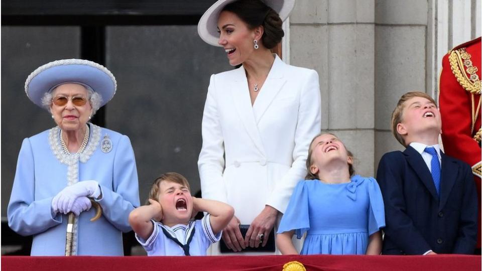 El príncipe Louis se tapa las orejas y grita mientras está de pie junto a la reina Isabel.