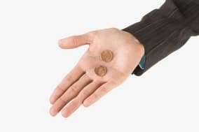 Studio shot of woman's hand holding two pennies